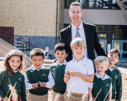 Head of School with students on playground.